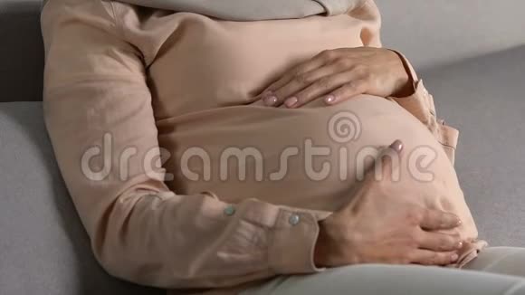 带着爱怀孕和母性的头巾抚摸着腹部的轻松女人视频的预览图