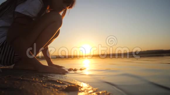 日落时分在海中嬉戏的女孩慢动作视频的预览图