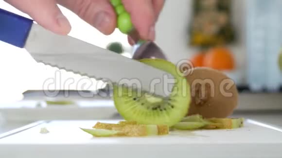 一个男人用刀把一个猕猴桃切成许多片做成水果沙拉视频的预览图
