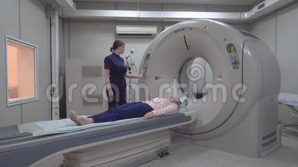 在一家新的现代癌症治疗医院的CT扫描室旁边有电脑和监视器的扫描室视频的预览图