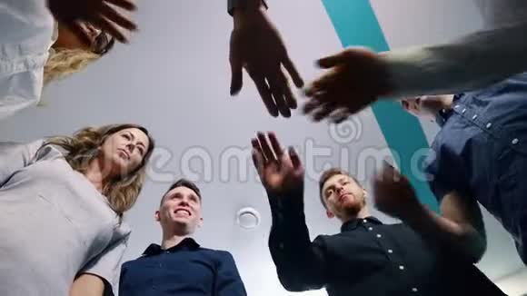 成功的团队在办公室许多手举在一起站在圆圈里团队建设理念视频的预览图