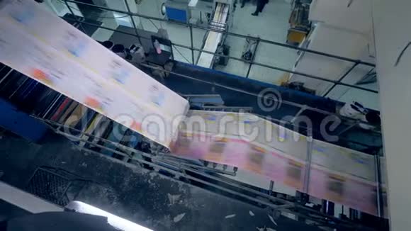 新鲜印刷纸在工业机器中移动的俯视图视频的预览图