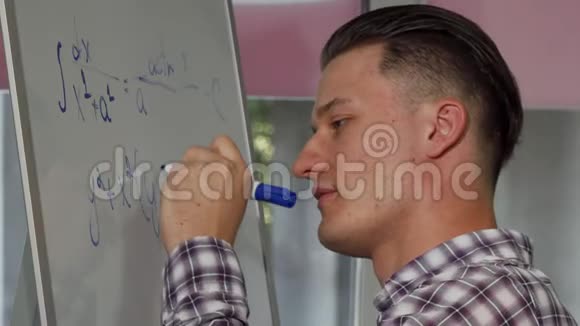 英俊的年轻人在白板上解决数学问题视频的预览图