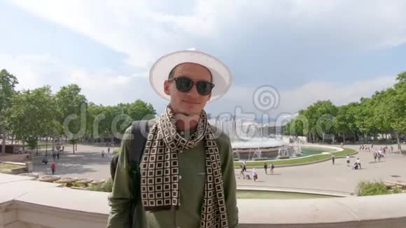 一个年轻的微笑的人带着背包站着的游客戴着帽子崇拜魔法蒙朱伊奇视频的预览图