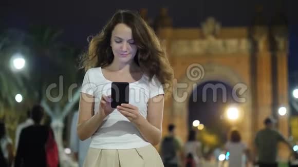 巴塞罗那晚上使用手机的美丽女孩的肖像视频的预览图