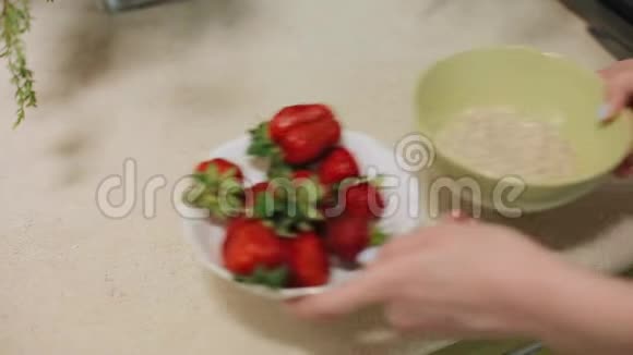 美味健康的食物有草莓的燕麦片特写镜头女人手把一块鲜坯切成一盘粥视频的预览图