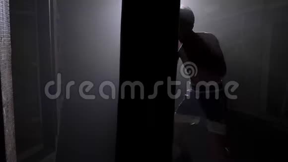 砖楼拳击手剪影拳击袋训练大战斗雾和明亮照明视频的预览图