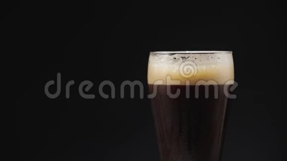 在装有水滴的杯子里喝杯冷黑啤酒视频的预览图