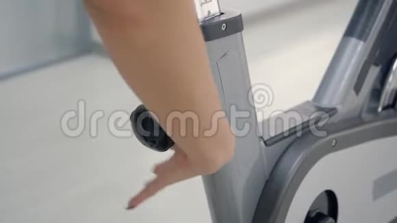 女人在她的旋转自行车上调整座位视频的预览图