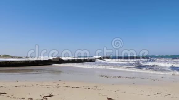 在阳光明媚的多风天气里强烈的海浪拍打着码头和沙滩塞浦路斯海滩暴风雨天气视频的预览图