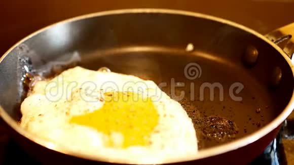 新鲜的鸡蛋和磨尖的胡椒在热炒锅里炒蒸汽上升视频的预览图