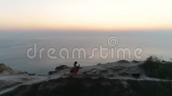 女人带着瑜伽垫走在悬崖边上视频的预览图