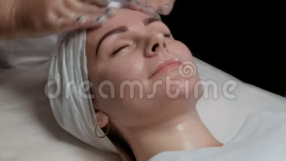 美容保健水疗在美容院做皮肤清洁的女人透明手套上的美容师视频的预览图