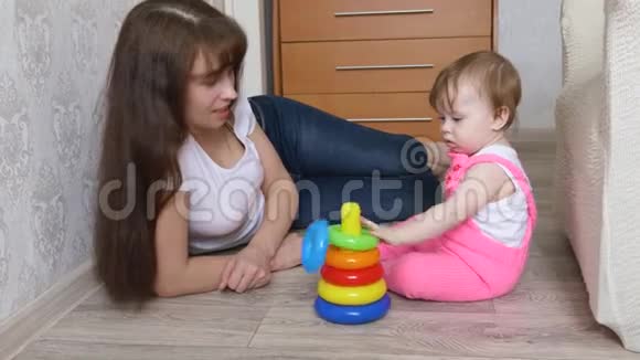 小女儿和妈妈玩五颜六色的戒指收集玩具金字塔视频的预览图