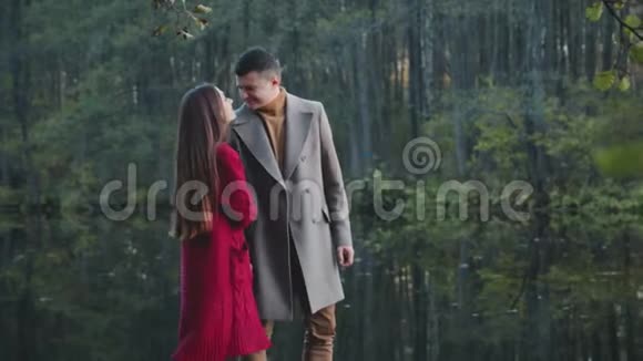 在公园里在森林湖的背景下一对年轻可爱的夫妇亲吻和拥抱视频的预览图