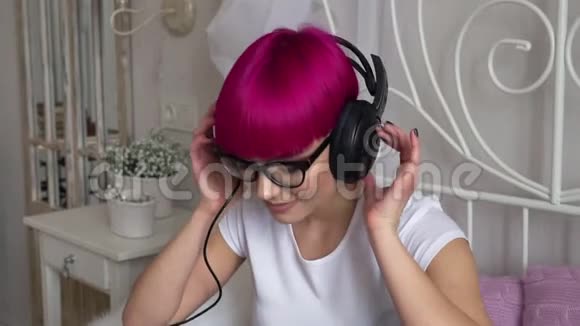 戴眼镜的女孩听耳机里的音乐视频的预览图