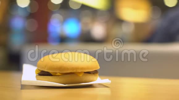女人从咖啡桌上拿汉堡把咬过的三明治放回去视频的预览图