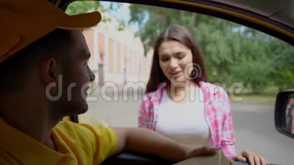 友好的男性送货员坐在车里给女人送包裹视频的预览图