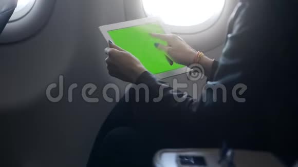 女士在轻型明亮飞机上使用平板电脑视频的预览图