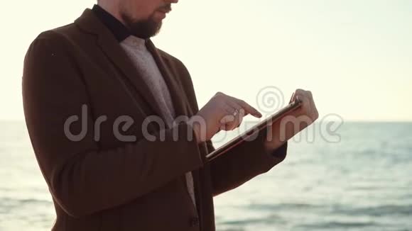 带着平板电脑的人在海滩上视频的预览图