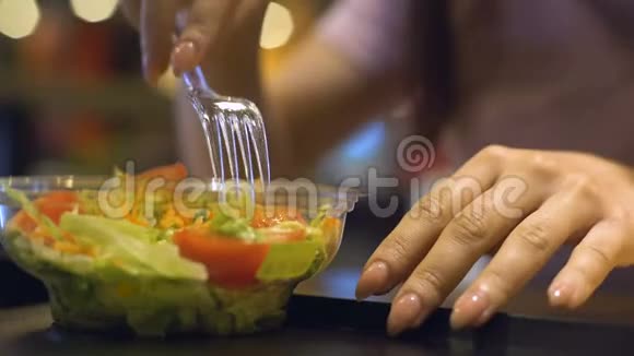 女性从塑料盘子里拿蔬菜沙拉晚餐休息减肥视频的预览图