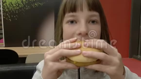 年轻快乐的少年在快餐店吃美味的汉堡包小女孩吃炸薯条晚餐视频的预览图