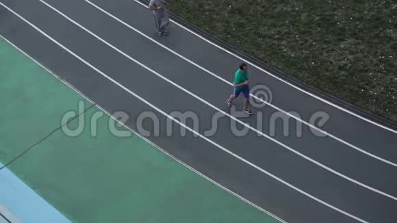 人们沿着体育场顶上的跑步机跑步视频的预览图