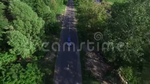 通过夏季森林鸟瞰汽车在乡村道路上行驶视频的预览图