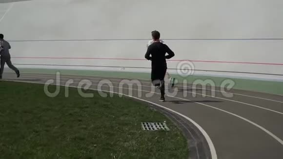 在体育场的跑步机上跑步的男人视频的预览图