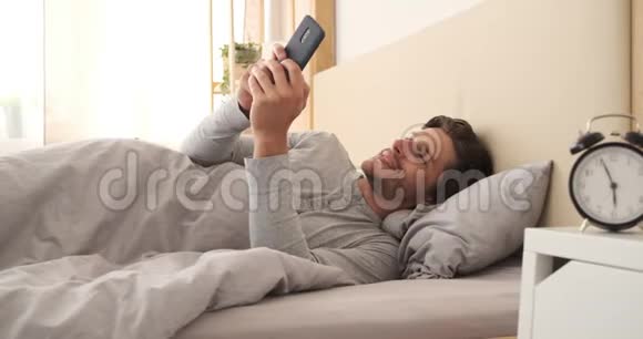 男人在床上用手机视频的预览图