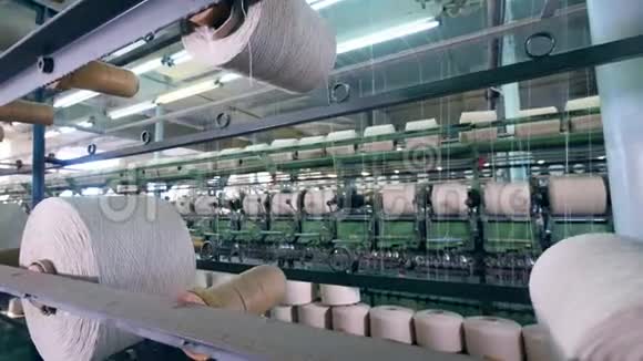 白线在卷筒之间机械地重新定位纺织厂设备视频的预览图