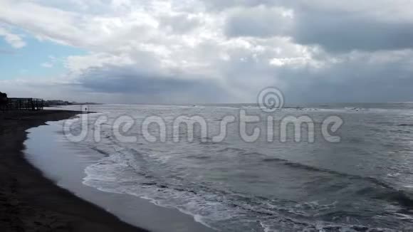 大海在海滩上摇晃一个孤独的人在岸上行走视频的预览图