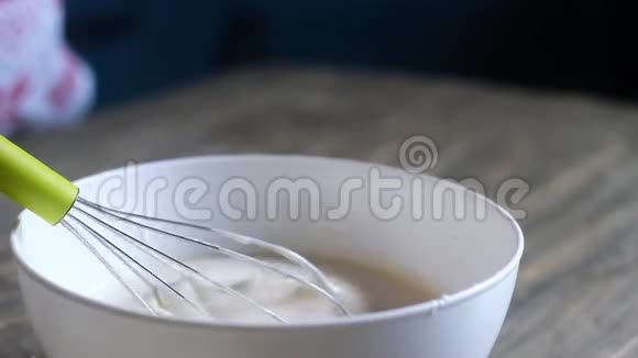 厨师用金属搅拌器将奶油搅拌均匀液体酱流下盘子视频的预览图