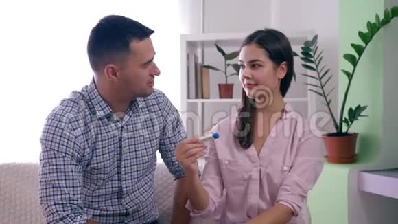幸福健康的已婚夫妇通过怀孕测试了解了未来的孩子并在家中拥抱视频的预览图