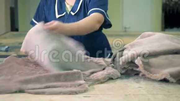 女工人把动物毛皮放在工厂的桌子上关门视频的预览图