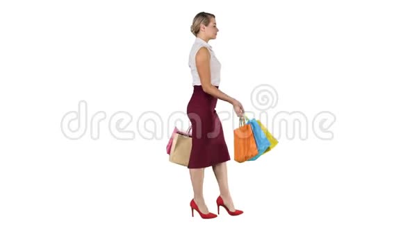 购物愉快女人拿着五颜六色的购物袋走在白色的背景上视频的预览图