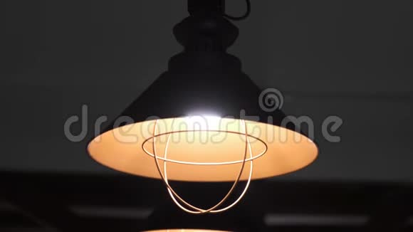 温暖的电灯来自深色背景上涂有黑色和橙色的装饰灯这些灯固定在上面视频的预览图