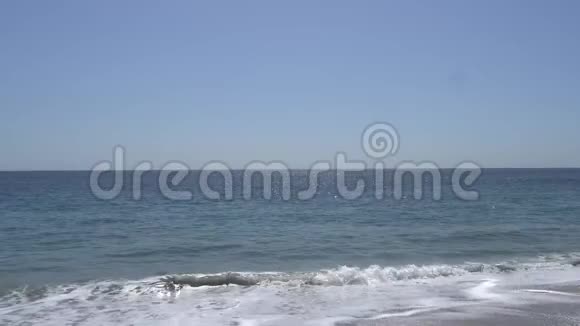 太平洋的波浪在加州马里布海滩的岸边拍打沙滩上温暖阳光的夏日视频的预览图