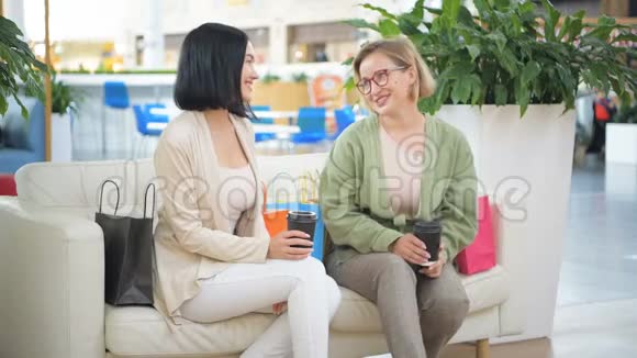 两个女朋友在购物中心玩得开心休息喝咖啡聊天视频的预览图