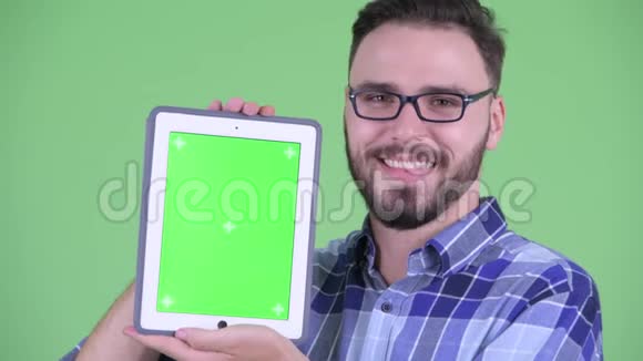 一位年轻的留胡子的年轻时髦男人展示数码平板电脑视频的预览图