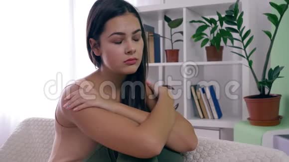 女性抑郁忧郁的女孩对精神疾病漠不关心坐在沙发上明亮的房间在家里视频的预览图