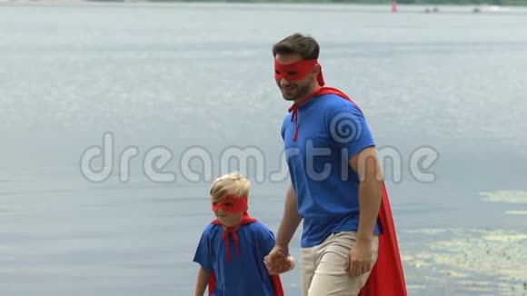 父亲帮助儿子跳得更高超级英雄家庭团队团结缓慢视频的预览图