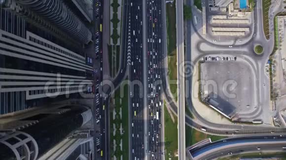 汽车驾驶在未来的建筑现代迪拜摩天大楼全景在惊人的顶级无人机空中飞行视频的预览图