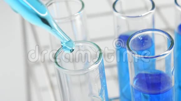 将蓝色液体滴入实验室试管中视频的预览图