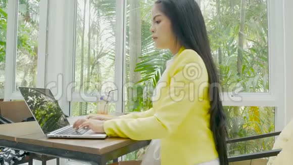 4K镜头女商人在咖啡店用手提电脑键盘打字视频的预览图