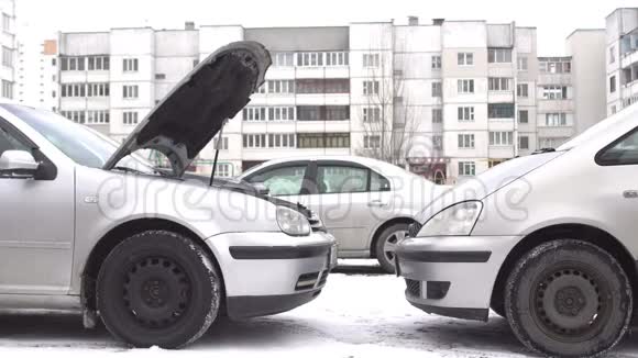 一个男人准备一个汽车捐献者在冬天用放电电池启动一辆汽车跳跃启动蓄能器视频的预览图