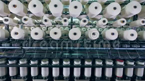 纺织厂在带有线轴的工业机器上进行的裁剪过程视频的预览图