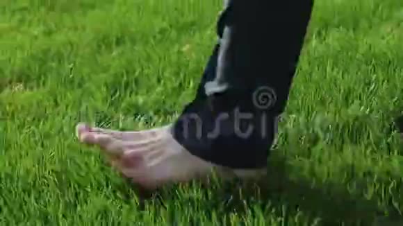 穿西装的人赤脚走在草坪上上班族下班后放松特写镜头视频的预览图