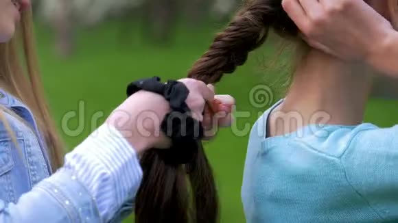 两个小女孩在户外做发型视频的预览图