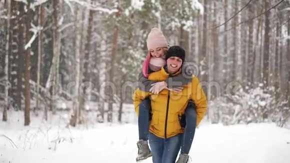 幸福的情侣漫步在白雪皑皑的冬林中一起度过圣诞假期户外季节性活动视频的预览图